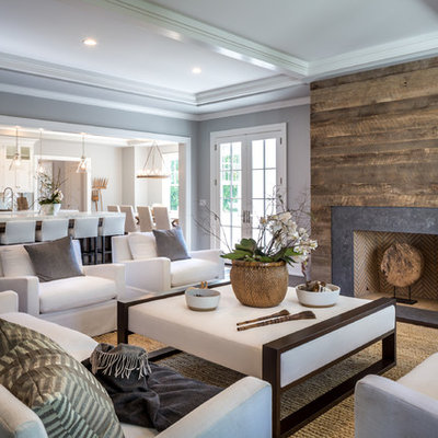 Inspiration for a transitional carpeted family room remodel in New York with gray walls, a standard fireplace and no tv
