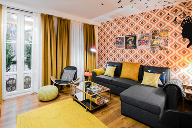 Modelo de sala de estar cerrada bohemia de tamaño medio sin chimenea con paredes multicolor y suelo de madera en tonos medios