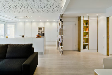Imagen de sala de estar con rincón musical abierta contemporánea de tamaño medio con paredes blancas, suelo laminado, televisor independiente y suelo gris