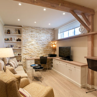 Foto de sala de estar cerrada, mediterránea, con paredes beige, suelo de madera clara, televisor colgado en la pared y suelo beige