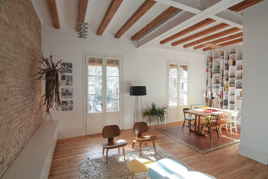 Imagen de sala de estar con biblioteca cerrada actual de tamaño medio sin chimenea y televisor con paredes blancas y suelo de madera en tonos medios