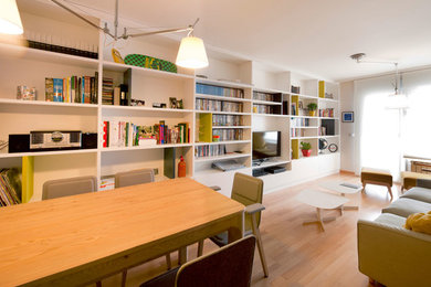 Diseño de sala de estar con biblioteca cerrada escandinava grande sin chimenea con paredes blancas, suelo de madera en tonos medios y televisor independiente