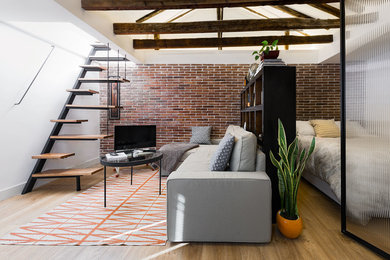Modelo de sala de estar abierta industrial pequeña con paredes blancas y suelo de madera en tonos medios