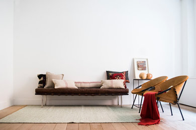 Ejemplo de sala de estar cerrada minimalista de tamaño medio sin chimenea con paredes blancas y suelo de madera en tonos medios