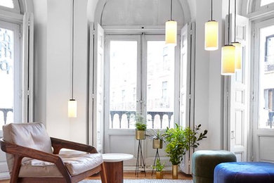 Imagen de sala de estar contemporánea de tamaño medio sin chimenea y televisor con paredes blancas y suelo de madera en tonos medios