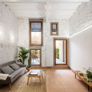 Modelo de sala de estar abierta, actual, de tamaño medio, con paredes blancas, suelo de baldosas de terracota y suelo rojo