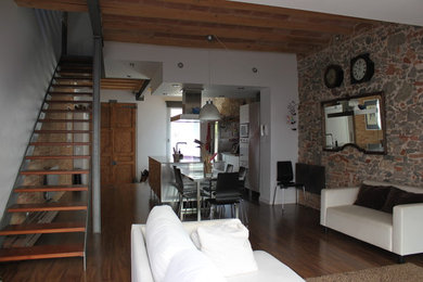 Foto de sala de estar abierta actual de tamaño medio sin chimenea y televisor con paredes blancas y suelo de madera en tonos medios