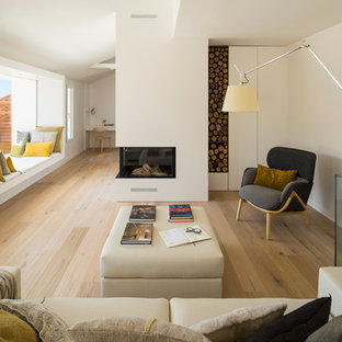 Mittelgroßes, Fernseherloses Skandinavisches Wohnzimmer mit weißer Wandfarbe, braunem Holzboden und Eckkamin in Barcelona