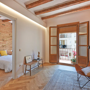 Imagen de sala de estar mediterránea con paredes blancas y suelo de madera en tonos medios