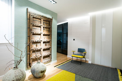 Modelo de sala de estar cerrada contemporánea de tamaño medio sin chimenea y televisor con paredes multicolor y suelo de madera en tonos medios