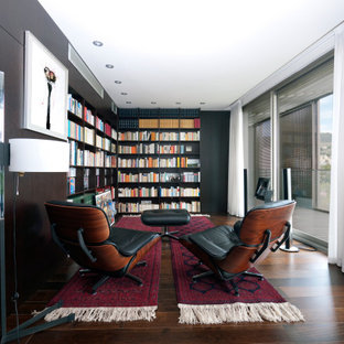 Foto de sala de estar con biblioteca actual, grande, con suelo de madera oscura, paredes negras y suelo marrón