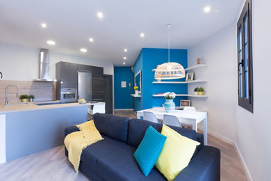 Foto de sala de estar abierta actual de tamaño medio sin chimenea y televisor con paredes multicolor y suelo de madera en tonos medios