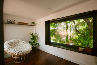 Imagen de sala de estar abierta de estilo zen pequeña sin televisor con paredes blancas y suelo de madera oscura