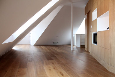 Ejemplo de sala de estar abierta actual pequeña con paredes blancas, suelo de madera en tonos medios y suelo marrón