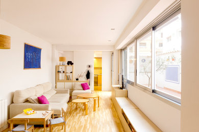 Foto de sala de estar cerrada contemporánea con paredes blancas, suelo de madera clara y televisor independiente
