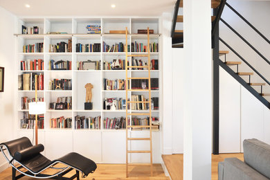Foto de sala de estar contemporánea con paredes blancas, suelo de madera en tonos medios y suelo marrón