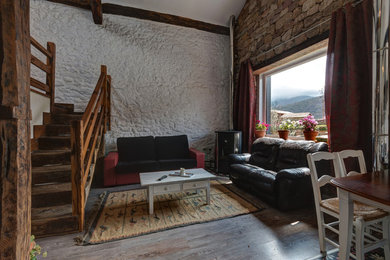 Imagen de sala de estar abierta rural de tamaño medio sin televisor con paredes multicolor, suelo de madera oscura y chimenea de esquina
