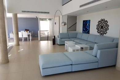 Modelo de sala de estar abierta moderna grande con paredes azules, suelo de baldosas de porcelana y suelo beige