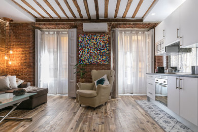 Ejemplo de sala de estar abierta contemporánea pequeña con suelo de madera clara y televisor colgado en la pared