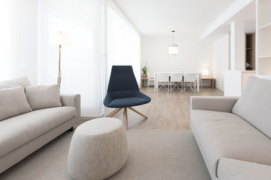 Modelo de sala de estar abierta mediterránea pequeña con paredes blancas, suelo de baldosas de cerámica, televisor colgado en la pared y suelo marrón