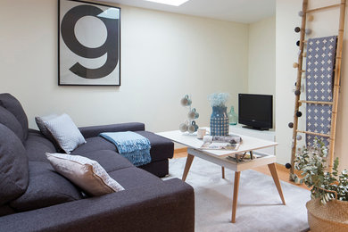 Diseño de sala de estar cerrada nórdica pequeña sin chimenea con suelo de madera en tonos medios, pared multimedia y paredes blancas