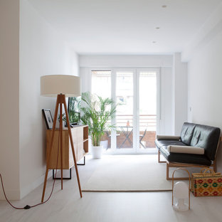 Imagen de sala de estar cerrada, minimalista, de tamaño medio, con paredes blancas, televisor independiente, suelo de madera clara y suelo beige