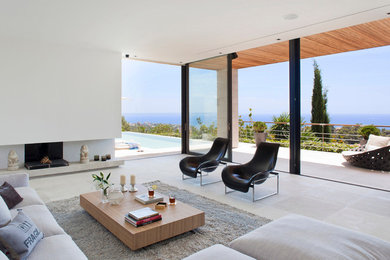 Imagen de sala de estar abierta mediterránea grande con paredes blancas, suelo de piedra caliza y chimenea de esquina