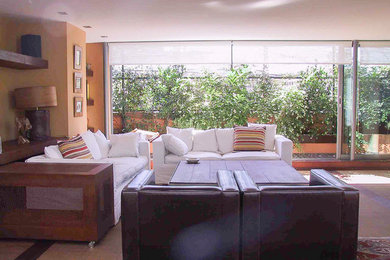 Imagen de sala de estar abierta actual sin televisor con parades naranjas, suelo de bambú y suelo marrón
