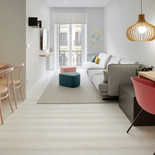 Foto de sala de estar abierta, actual, con suelo de madera clara, televisor colgado en la pared, paredes blancas y suelo beige