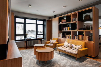 Diseño de sala de estar con biblioteca tipo loft actual extra grande sin televisor con paredes blancas y suelo de madera en tonos medios