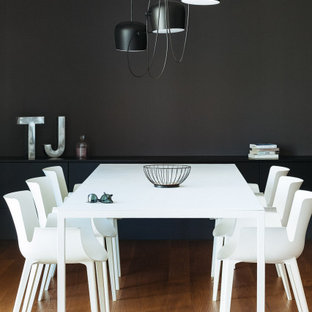 Esempio di una sala da pranzo design di medie dimensioni con pareti nere e pavimento marrone