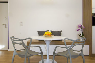 Ispirazione per una piccola sala da pranzo aperta verso il soggiorno minimal con pareti bianche e parquet chiaro