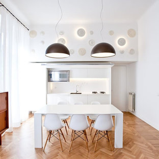 Idee per una sala da pranzo aperta verso la cucina minimalista di medie dimensioni con pavimento in legno massello medio, pavimento marrone e pareti bianche