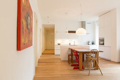 Diseño de comedor contemporáneo con paredes blancas y suelo de madera clara
