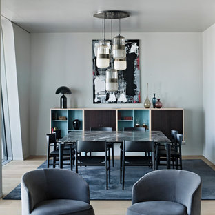 Foto di una sala da pranzo aperta verso il soggiorno minimalista di medie dimensioni con pavimento in legno massello medio, nessun camino, pavimento marrone e pareti bianche