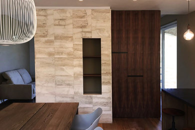 Ispirazione per una sala da pranzo aperta verso il soggiorno design con pavimento in legno massello medio e camino classico