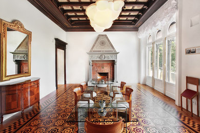 Esempio di una sala da pranzo classica chiusa con pareti bianche, camino classico, cornice del camino in mattoni e parquet chiaro