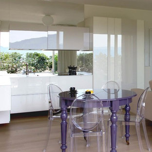 Immagine di una sala da pranzo aperta verso la cucina design con pareti bianche, parquet chiaro e pavimento beige