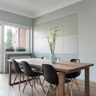 Idee per una sala da pranzo aperta verso il soggiorno design con pareti verdi, parquet chiaro e nessun camino