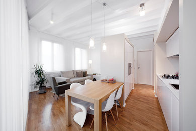 Esempio di una sala da pranzo aperta verso la cucina contemporanea con pareti bianche e pavimento in legno massello medio