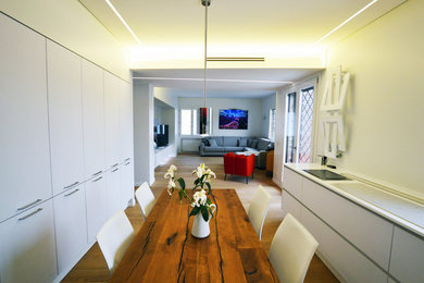 Réalisation d'une grande salle à manger ouverte sur la cuisine design avec un mur blanc, parquet clair et un sol marron.