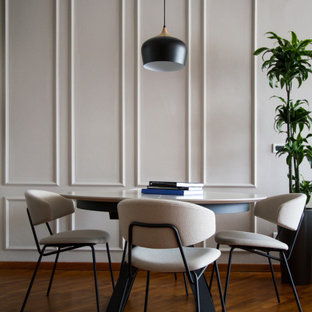 Foto di una sala da pranzo contemporanea con pareti grigie, pavimento in legno massello medio, pavimento marrone e pannellatura