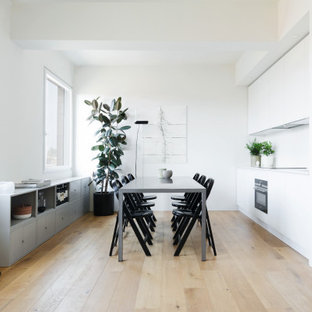 Idéer för att renovera en funkis matplats, med vita väggar och målat trägolv