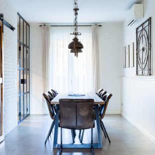 Idee per una sala da pranzo industriale di medie dimensioni con pareti bianche, pavimento in gres porcellanato, pavimento grigio e boiserie