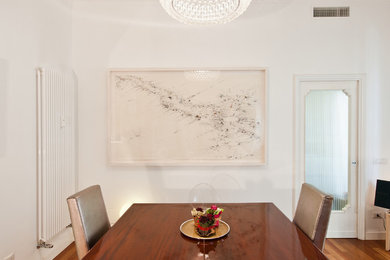 Foto de comedor contemporáneo con paredes blancas y suelo de madera oscura