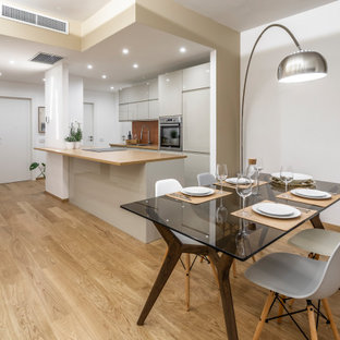 Foto di una sala da pranzo aperta verso la cucina contemporanea di medie dimensioni con pareti bianche, pavimento in legno massello medio e pavimento beige