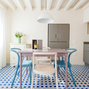 Immagine di una sala da pranzo aperta verso la cucina mediterranea con pareti bianche, pavimento con piastrelle in ceramica e pavimento blu