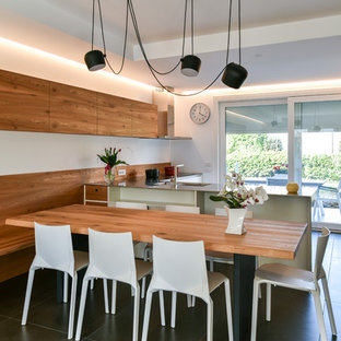 Ispirazione per una sala da pranzo aperta verso la cucina design di medie dimensioni con pareti bianche, pavimento con piastrelle in ceramica, nessun camino e pavimento nero