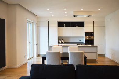 Foto di una grande sala da pranzo aperta verso il soggiorno contemporanea con pareti bianche, pavimento in gres porcellanato e pavimento beige
