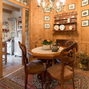 Small country separate dining room in Milan with brown walls, medium hardwood floors and brown floor.